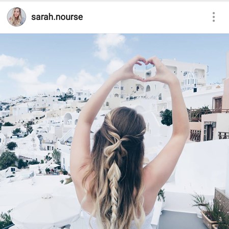 rozpuszczone włosy z warkoczem na środku, w tle santorini