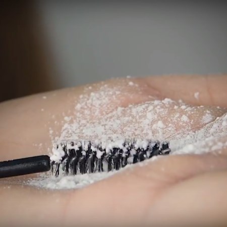 Szczoteczka od maskary otoczona w pudrze pielęgnacyjnym