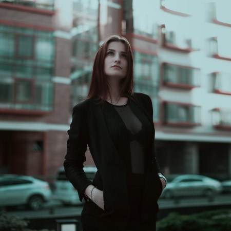 Dziewczyna w prześwitującej, czarnej bluzce i czarnej marynarce