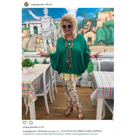 Magda Gessler w zielonej bluzce i białych spodniach w kwiaty