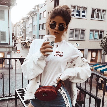Dziewczyna w białym T-shircie z kubkiem starbucksa w ręce
