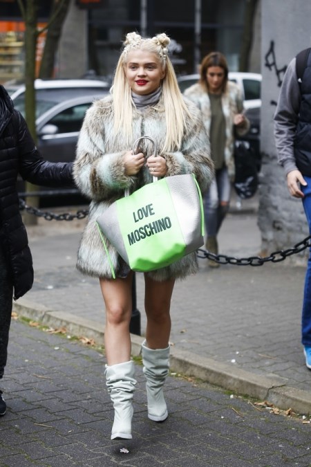 Margaret ubrana w szary golf, beżowo-szare futerko, szare kozaki do połowy łydki i z torebką typu shopper w ręku
