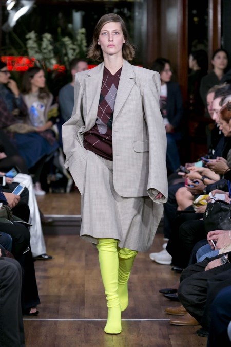 Modelka na pokazie Vetements w oversize'owej garsonce i limonkowych kozakach wiosennych.