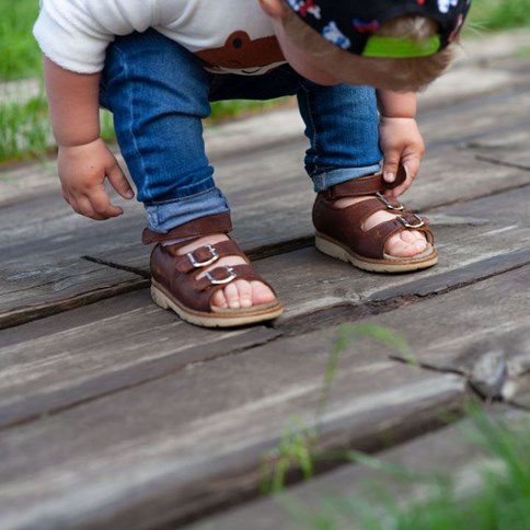 Chłopiec w brązowych sandałach 