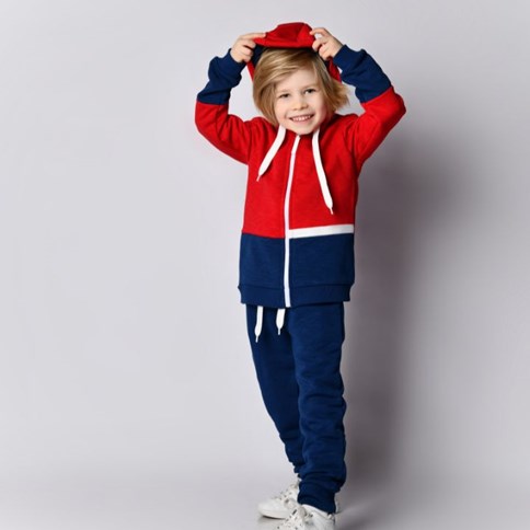 Chłopiec w niebiesko czerwonych dresach