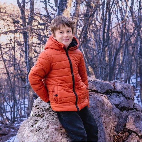 Chłopiec w pomarańczowej kurtce sportowej 