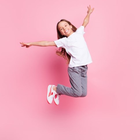 Dziewczynka w niebieskich spodniach i białej bluzce 