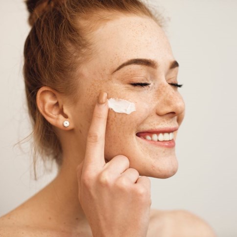 Kobieta nakładająca krem do twarzy