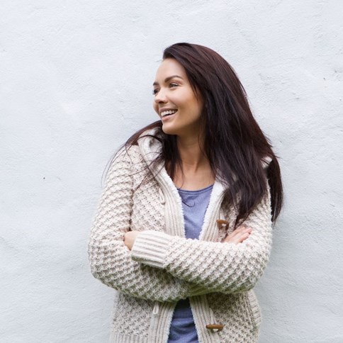 Kobieta w beżowym swetrze z kapturem