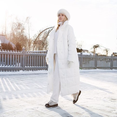 Kobieta w białym puchowym płaszczu