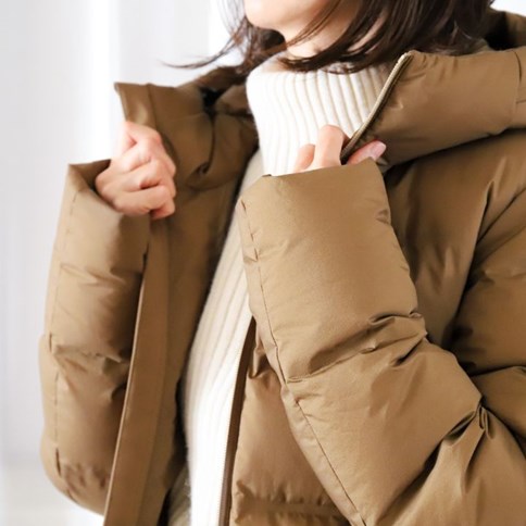 Kobieta w brązowej kurtce puchowej