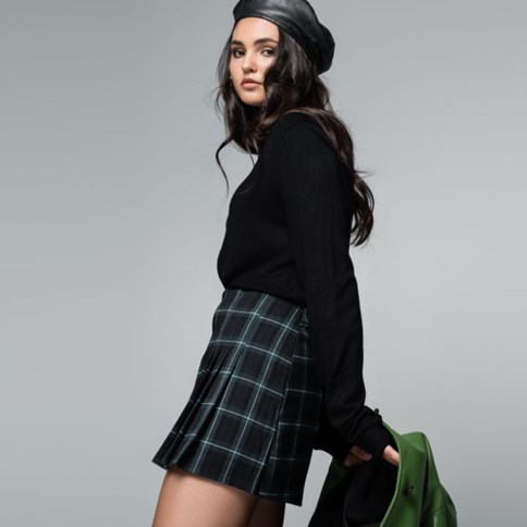Kobieta w czarnej spódnicy w kratę 