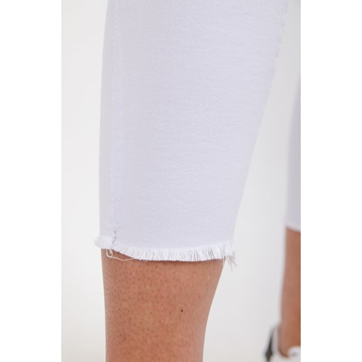 Białe przylegające spodnie z rozcięciami na kolanach Olika L okazja olika.com.pl