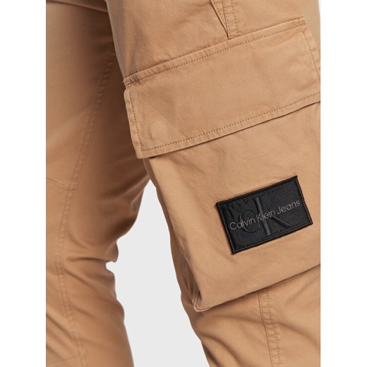 Calvin Klein Jeans Spodnie materiałowe J30J322043 Beżowy Regular Fit 32 okazja MODIVO
