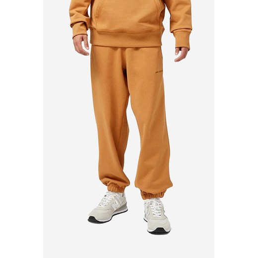 New Balance spodnie dresowe bawełniane kolor pomarańczowy gładkie (puste) ze sklepu PRM w kategorii Spodnie męskie - zdjęcie 161405585
