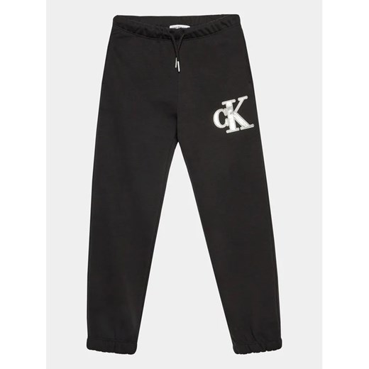 Calvin Klein Jeans Spodnie dresowe Metallic IG0IG02287 Czarny Regular Fit ze sklepu MODIVO w kategorii Spodnie chłopięce - zdjęcie 168379005
