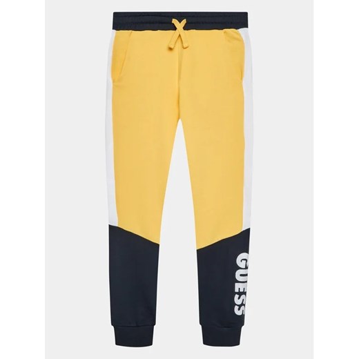 Guess Spodnie dresowe L3BQ11 KAX73 Żółty Regular Fit ze sklepu MODIVO w kategorii Spodnie chłopięce - zdjęcie 168466249