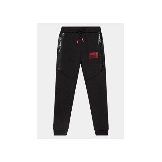 Guess Spodnie dresowe L4RQ13 KBO62 Czarny Regular Fit ze sklepu MODIVO w kategorii Spodnie chłopięce - zdjęcie 168606906