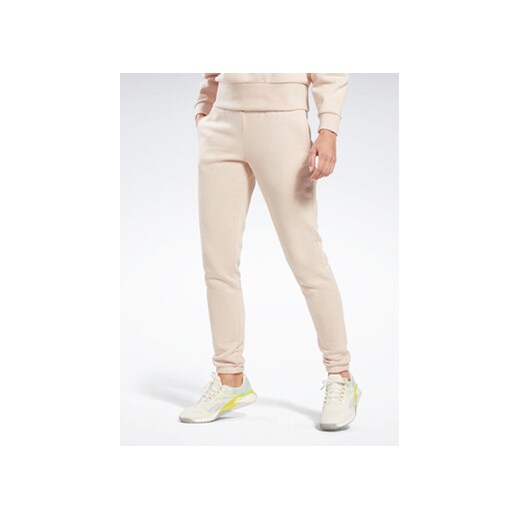 Reebok Spodnie dresowe Fleece IC3502 Beżowy Slim Fit ze sklepu MODIVO w kategorii Spodnie damskie - zdjęcie 168625388