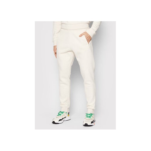 adidas Spodnie dresowe adicolor Essentials HE9410 Beżowy Slim Fit ze sklepu MODIVO w kategorii Spodnie męskie - zdjęcie 168639185