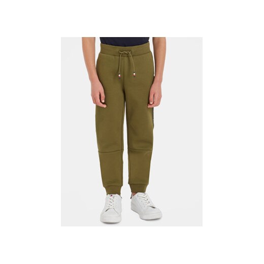 Tommy Hilfiger Spodnie dresowe Tape KB0KB08476 Zielony Regular Fit ze sklepu MODIVO w kategorii Spodnie chłopięce - zdjęcie 168641997