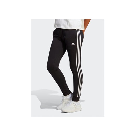 adidas Spodnie dresowe Essentials 3-Stripes French Terry Cuffed Joggers IC8770 Czarny Slim Fit ze sklepu MODIVO w kategorii Spodnie damskie - zdjęcie 169182047