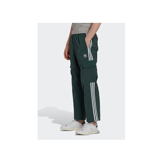 adidas Spodnie dresowe adicolor 3 Stripes HN6736 Zielony Relaxed Fit ze sklepu MODIVO w kategorii Spodnie męskie - zdjęcie 169183778