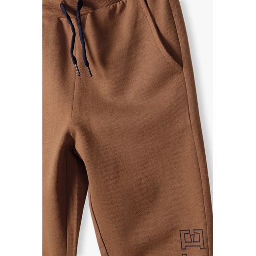 Brązowe spodnie dresowe slim fit chłopięce z napisem na nogawce Lincoln & Sharks By 5.10.15. 152 5.10.15