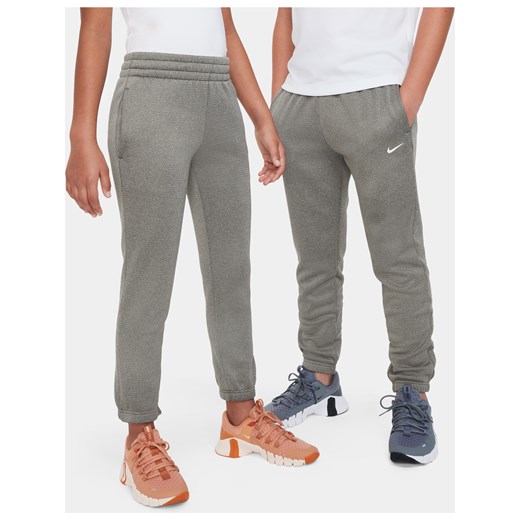Spodnie zimowe dla dużych dzieci Nike Therma-FIT - Zieleń ze sklepu Nike poland w kategorii Spodnie męskie - zdjęcie 169759117