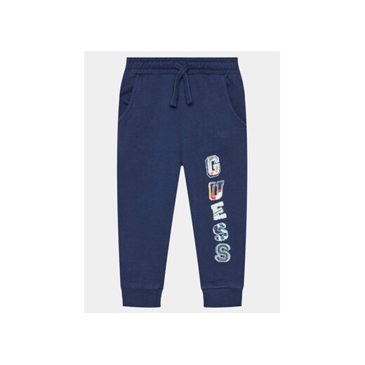 Guess Spodnie dresowe N4GQ11 KA6R3 Granatowy Regular Fit ze sklepu MODIVO w kategorii Spodnie chłopięce - zdjęcie 170477037