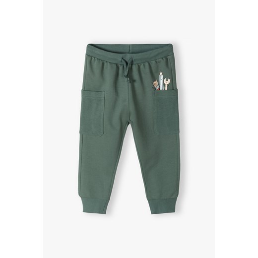 Zielone bawełniane spodnie dresowe niemowlęce z kieszonkami ze sklepu 5.10.15 w kategorii Spodnie i półśpiochy - zdjęcie 170729979