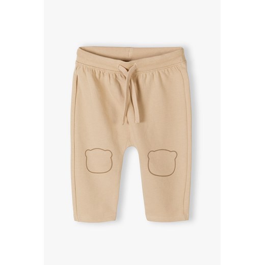 Beżowe bawełniane spodnie dresowe niemowlęce ze sklepu 5.10.15 w kategorii Spodnie i półśpiochy - zdjęcie 170850866