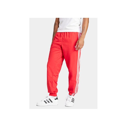 adidas Spodnie dresowe Adicolor Woven Firebird IT2498 Czerwony Regular Fit ze sklepu MODIVO w kategorii Spodnie męskie - zdjęcie 171344549