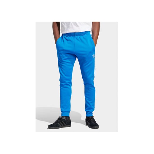 adidas Spodnie dresowe adicolor Classics SST IM4542 Niebieski Slim Fit ze sklepu MODIVO w kategorii Spodnie męskie - zdjęcie 171449416