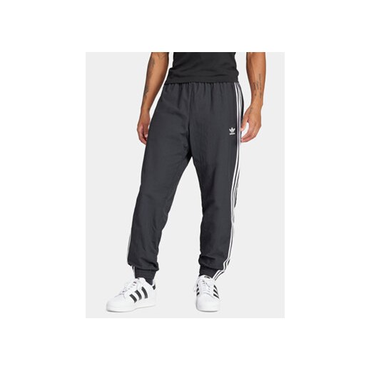 adidas Spodnie dresowe Adicolor Woven Firebird IT2501 Czarny Regular Fit ze sklepu MODIVO w kategorii Spodnie męskie - zdjęcie 172602828