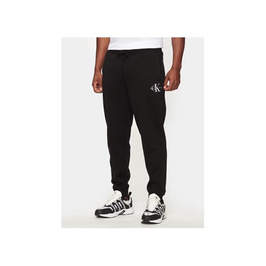 Calvin Klein Jeans Spodnie dresowe Monologo J30J325658 Czarny Regular Fit ze sklepu MODIVO w kategorii Spodnie męskie - zdjęcie 173410515