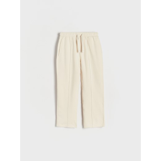 Reserved - Dresowe spodnie z przeszyciami - kremowy ze sklepu Reserved w kategorii Spodnie chłopięce - zdjęcie 173624039