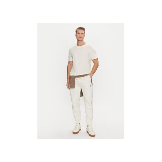 Calvin Klein Jeans Spodnie dresowe Monologo Hwk Pant J30J325658 Écru Regular Fit S MODIVO