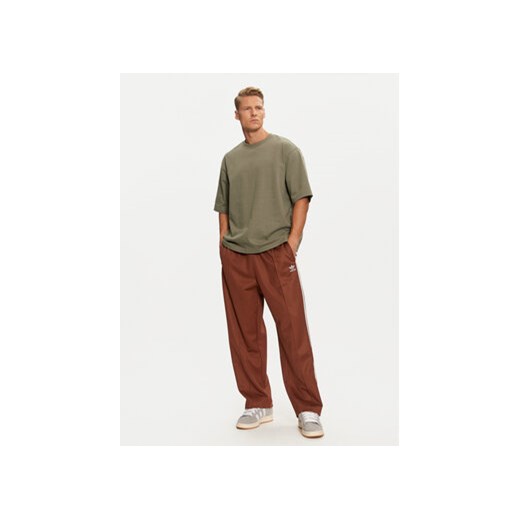adidas Spodnie dresowe adicolor Firebird IZ2476 Brązowy Baggy Fit M MODIVO