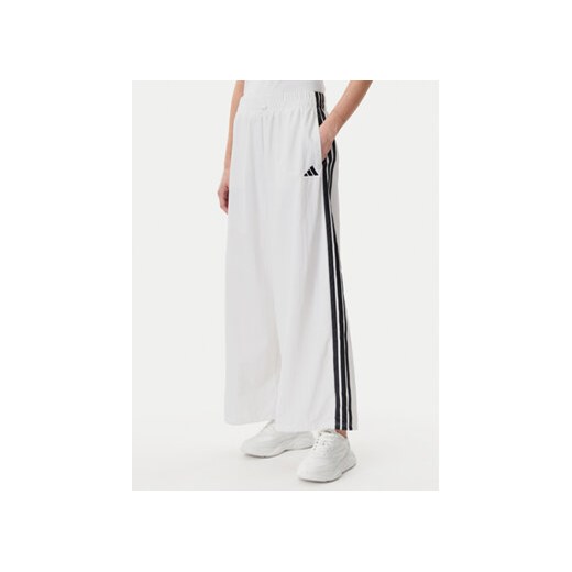 adidas Spodnie dresowe Essentials 3-Stripes JE1307 Biały Loose Fit ze sklepu MODIVO w kategorii Spodnie damskie - zdjęcie 178786395