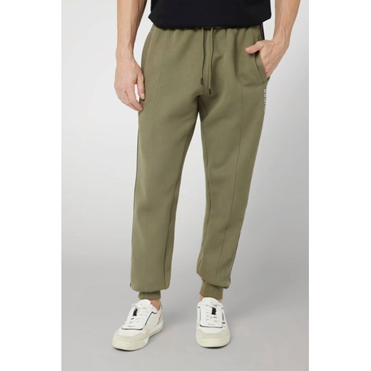 GUESS Zielone męskie spodnie dresowe z lampasami Mickey, Rozmiar M ze sklepu outfit.pl w kategorii Spodnie męskie - zdjęcie 179276115