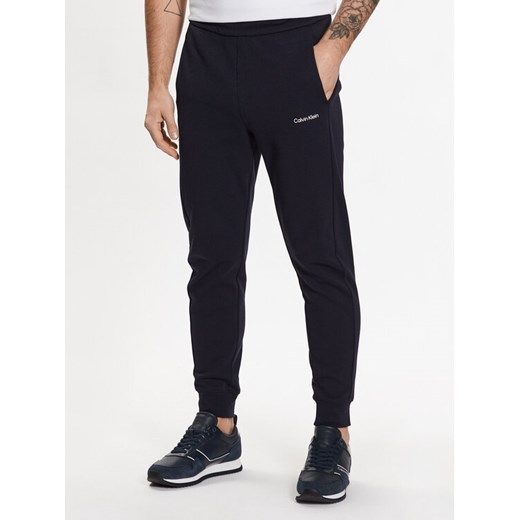 Calvin Klein Spodnie dresowe Micro Logo K10K109940 Granatowy Regular Fit ze sklepu MODIVO w kategorii Spodnie męskie - zdjęcie 182595958