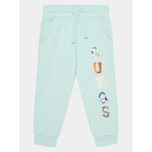 Guess Spodnie dresowe N4GQ11 KA6R3 Niebieski Regular Fit ze sklepu MODIVO w kategorii Spodnie chłopięce - zdjęcie 182606635