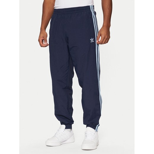 adidas Spodnie dresowe adicolor Firebird JP1249 Granatowy Regular Fit ze sklepu MODIVO w kategorii Spodnie męskie - zdjęcie 182607165