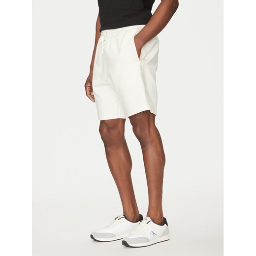 Calvin Klein Jeans Szorty sportowe Logo Tape J30J327246 Écru Regular Fit ze sklepu MODIVO w kategorii Spodenki męskie - zdjęcie 182611975