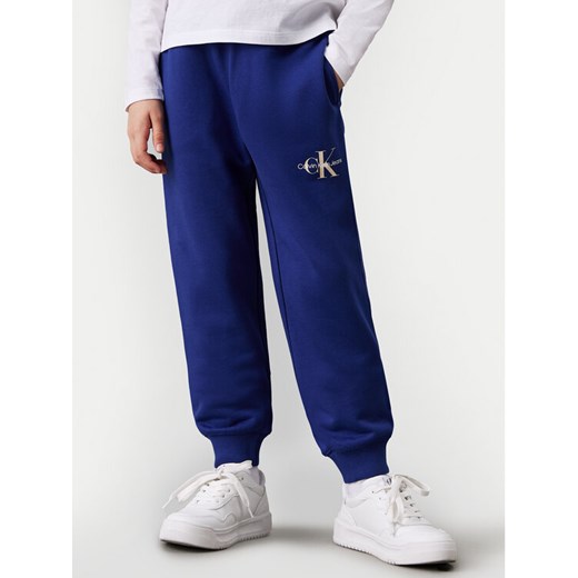 Calvin Klein Jeans Spodnie dresowe Monogram Logo IU0IU00285 Niebieski Regular Fit ze sklepu MODIVO w kategorii Spodnie chłopięce - zdjęcie 182631126