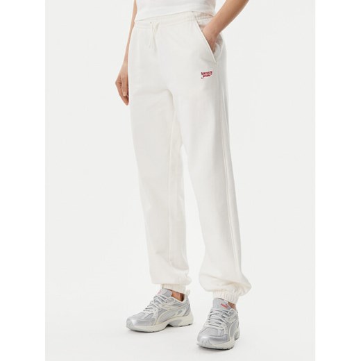 Tommy Jeans Spodnie dresowe Script DW0DW20670 Écru Relaxed Fit ze sklepu MODIVO w kategorii Spodnie damskie - zdjęcie 182632159