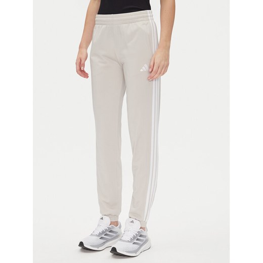 adidas Spodnie dresowe Tricot 3-Stripes JD4536 Beżowy Regular Fit ze sklepu MODIVO w kategorii Spodnie damskie - zdjęcie 182636357