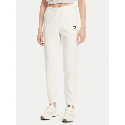 Tommy Jeans Spodnie dresowe Badge DW0DW20679 Écru Regular Fit ze sklepu MODIVO w kategorii Spodnie damskie - zdjęcie 182637526