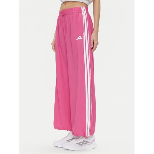 adidas Spodnie dresowe Essentials 3-Stripes JC8167 Różowy Loose Fit ze sklepu MODIVO w kategorii Spodnie damskie - zdjęcie 182649018